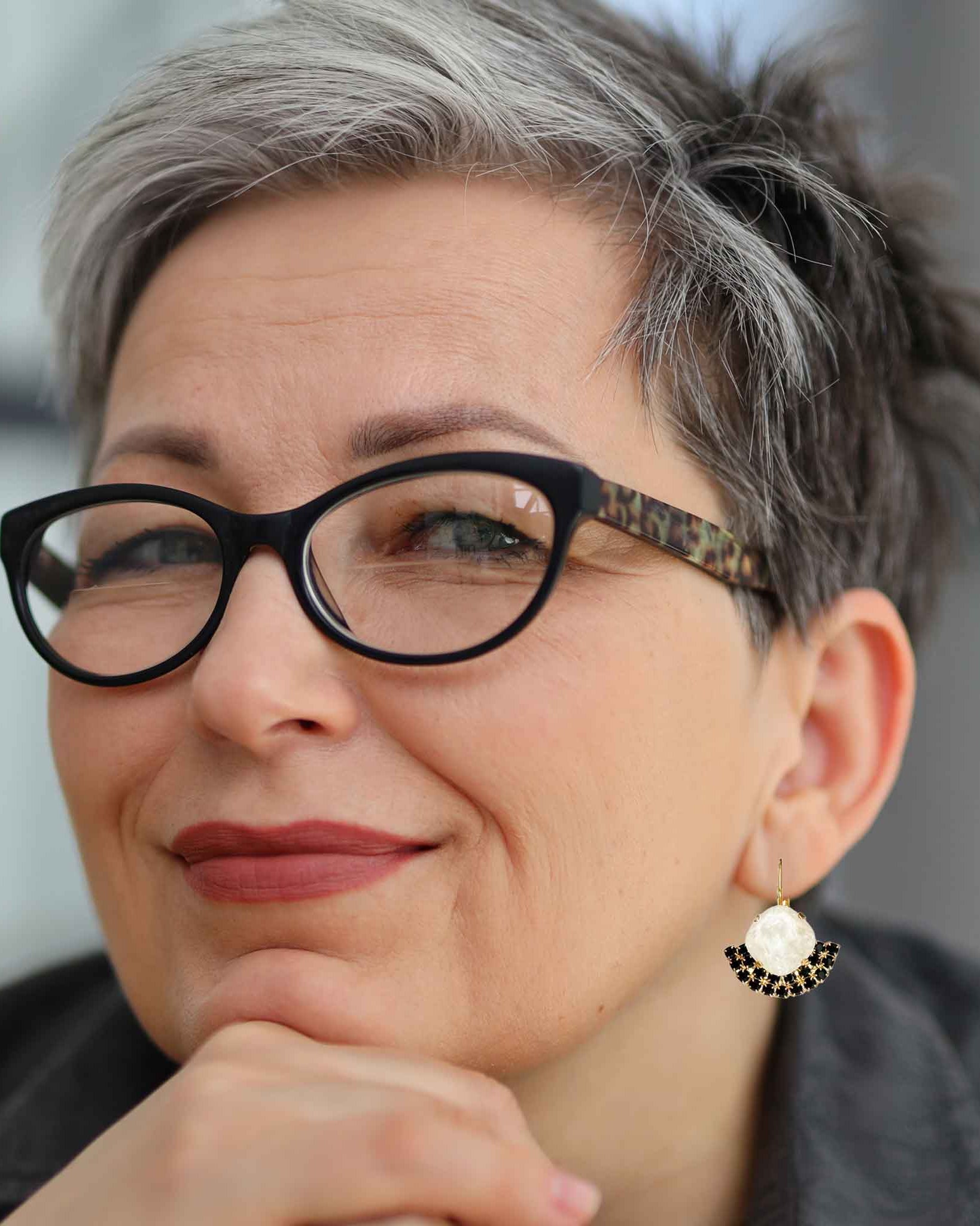 Boomer woman wearing black and white crystal earrings.