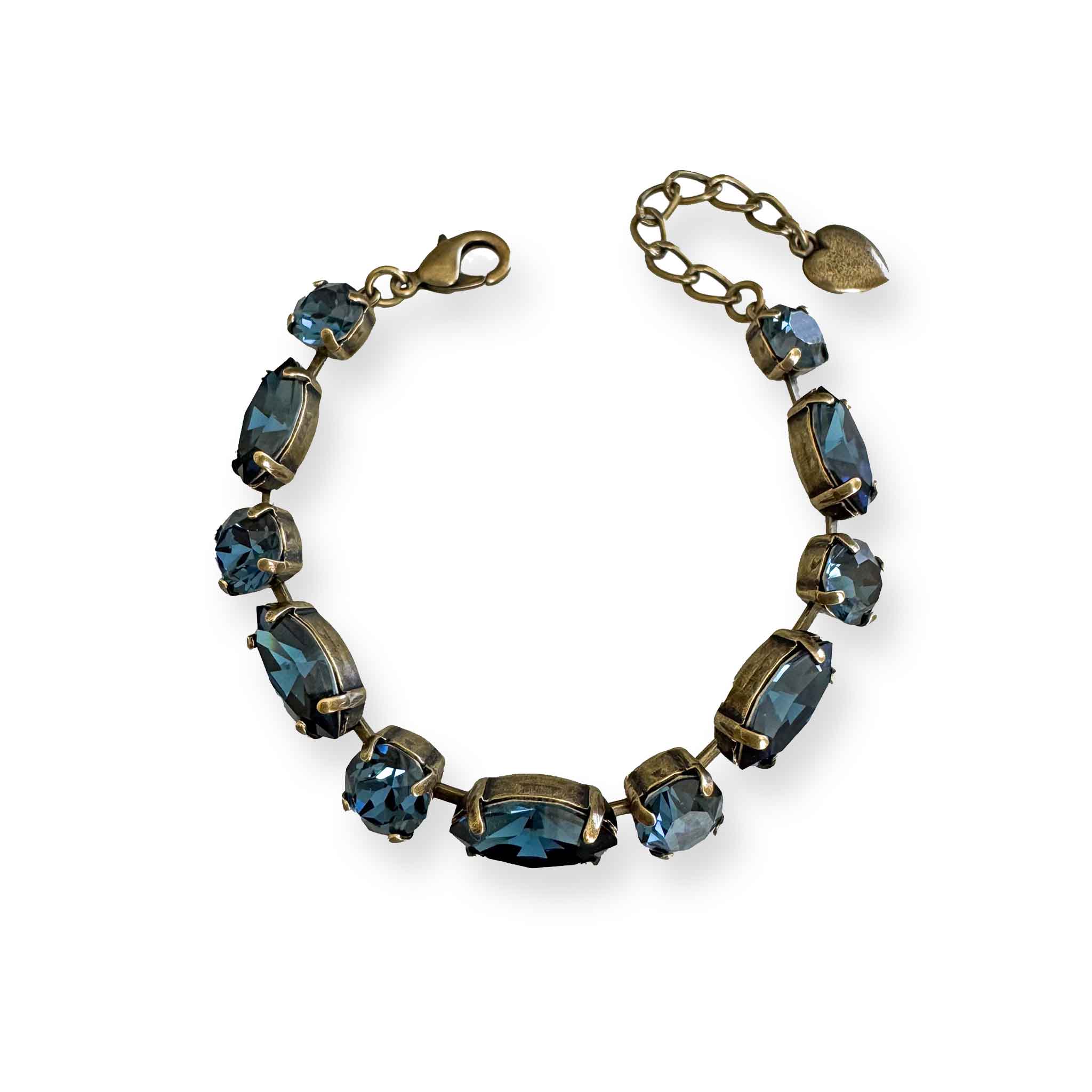 Antique brass bracelet with alternating oval and round denim blue crystals laid flat on a white background.