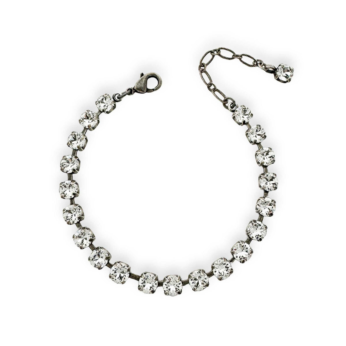 Delicate clear crystal tennis bracelet made of Swarovski crystal shown in antique silver.