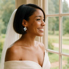 Black bride wearing white opal crystal leaf earrings by Petite Margaux.