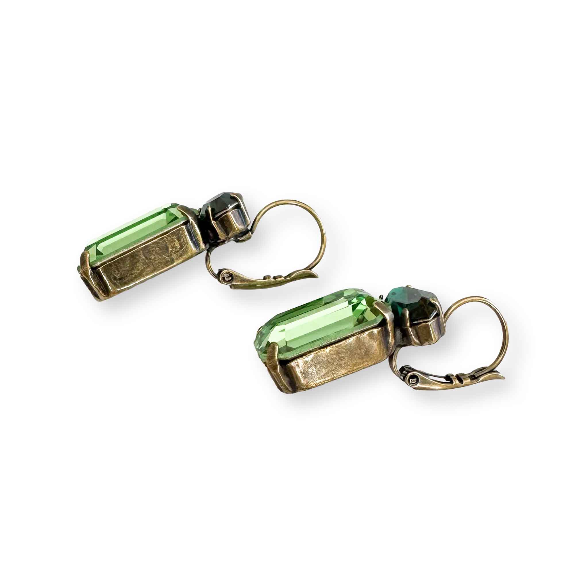 Another side view of dark and light green crystal drop earrings with emerald and marquise cut crystals shown in antique brass.