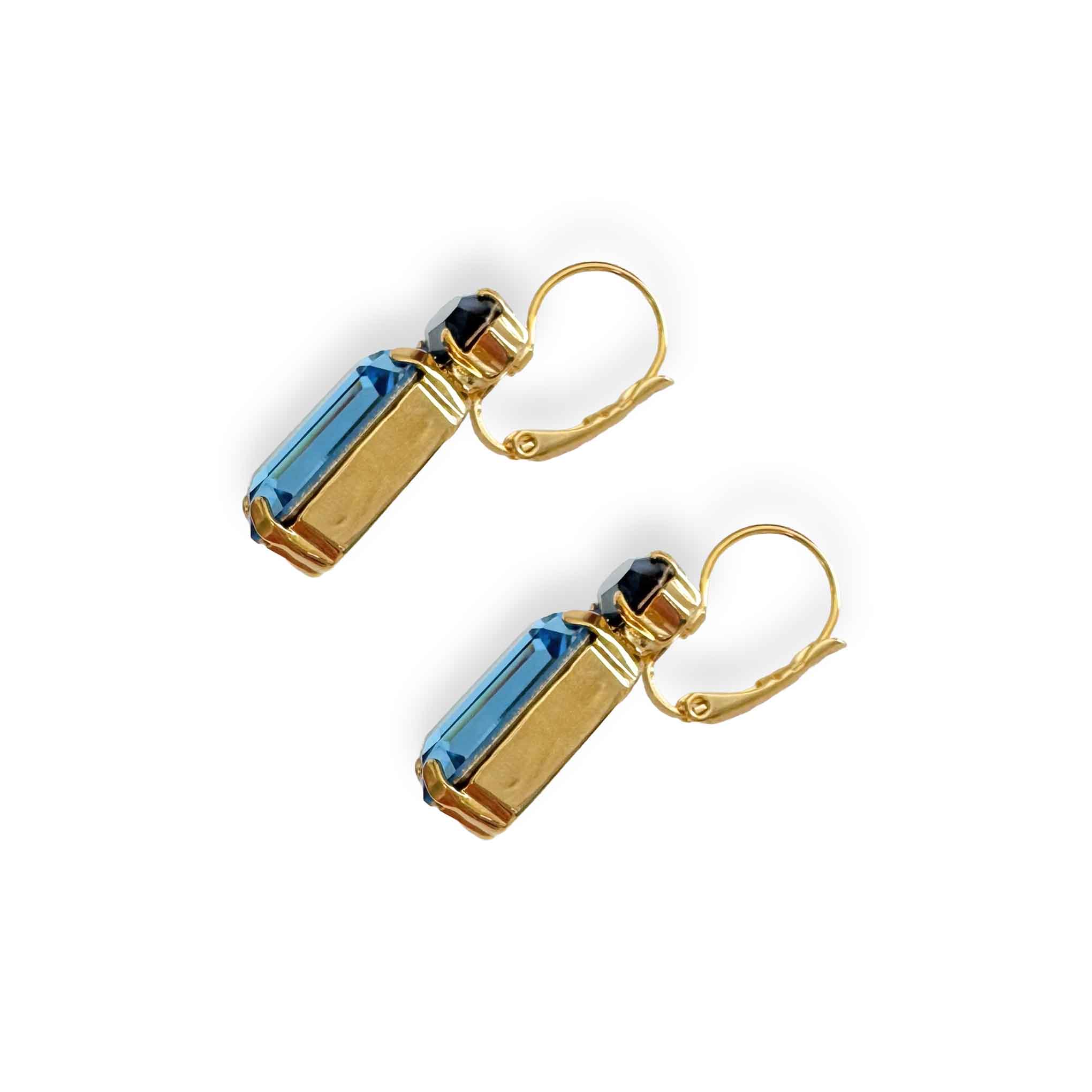 Side view of blue crystal earrings in a gold setting.