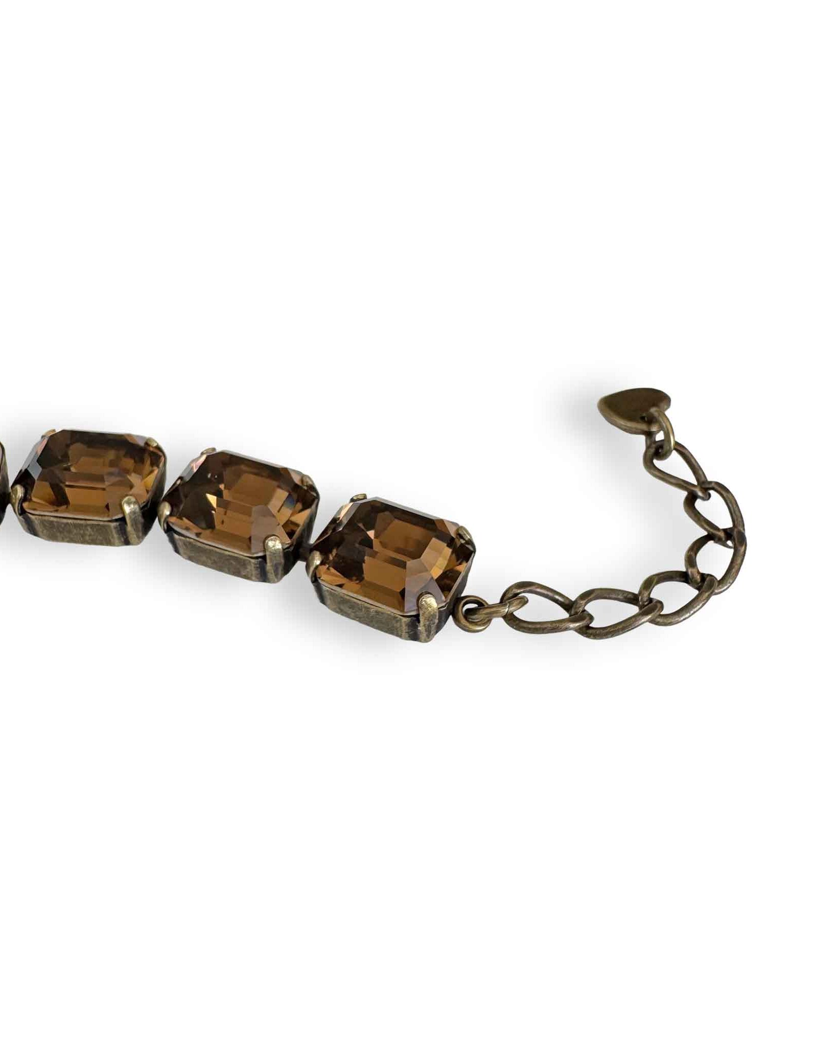 Close up of brown bracelet by Petite Margaux. Fine emerald cut European crystals set in warm antiqued brass with an adjustable extender.