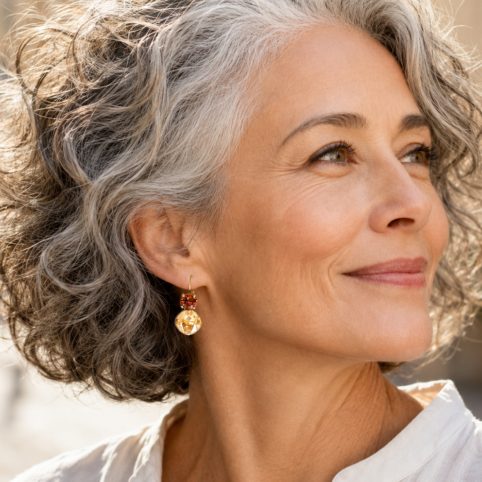 Close-up of brown and gold crystal earrings on a stylish mature woman.