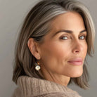 Beautiful, middle-aged woman wearing brown topaz crystal earrings by Petite Margaux.