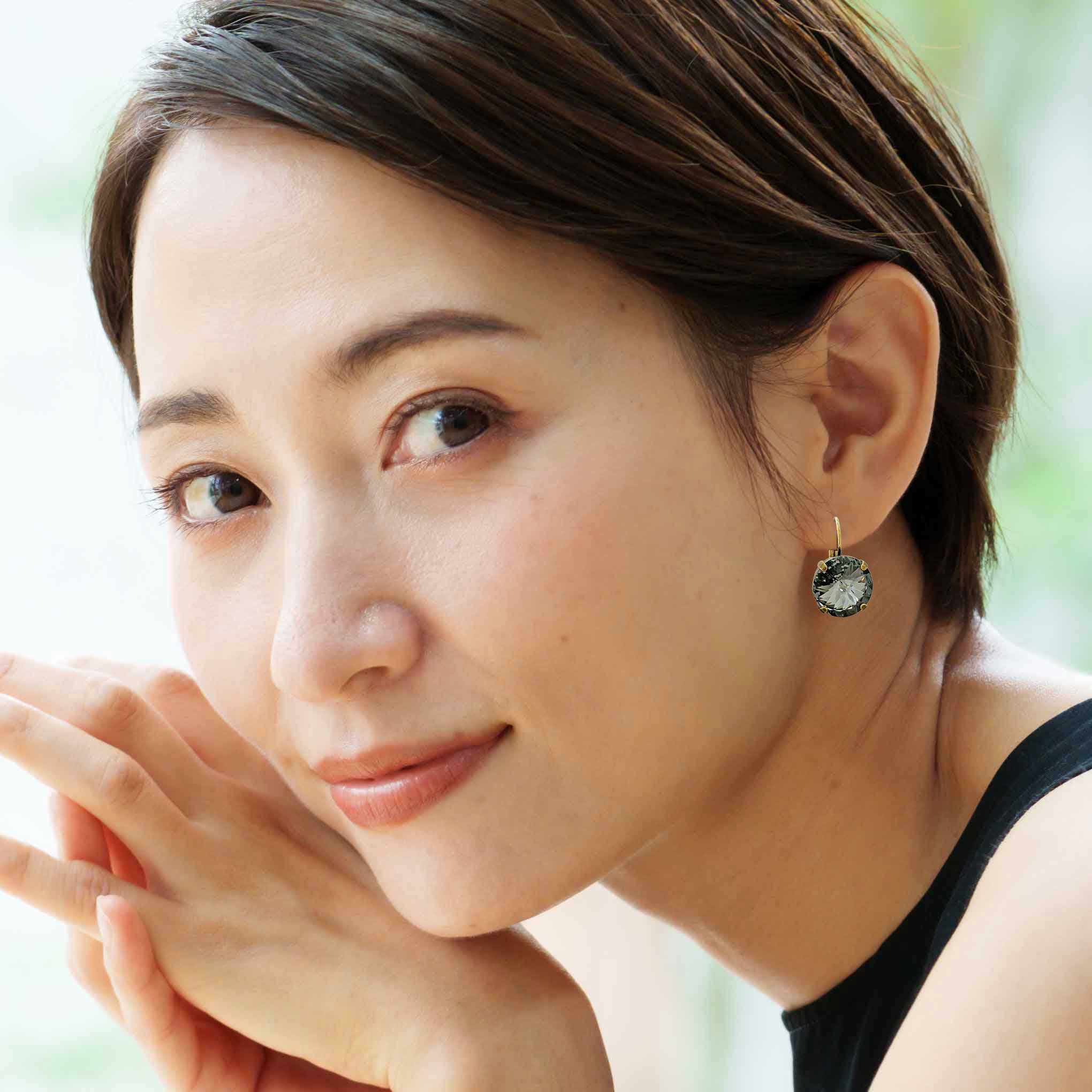 Asian woman wearing stunning black rivoli earrings.