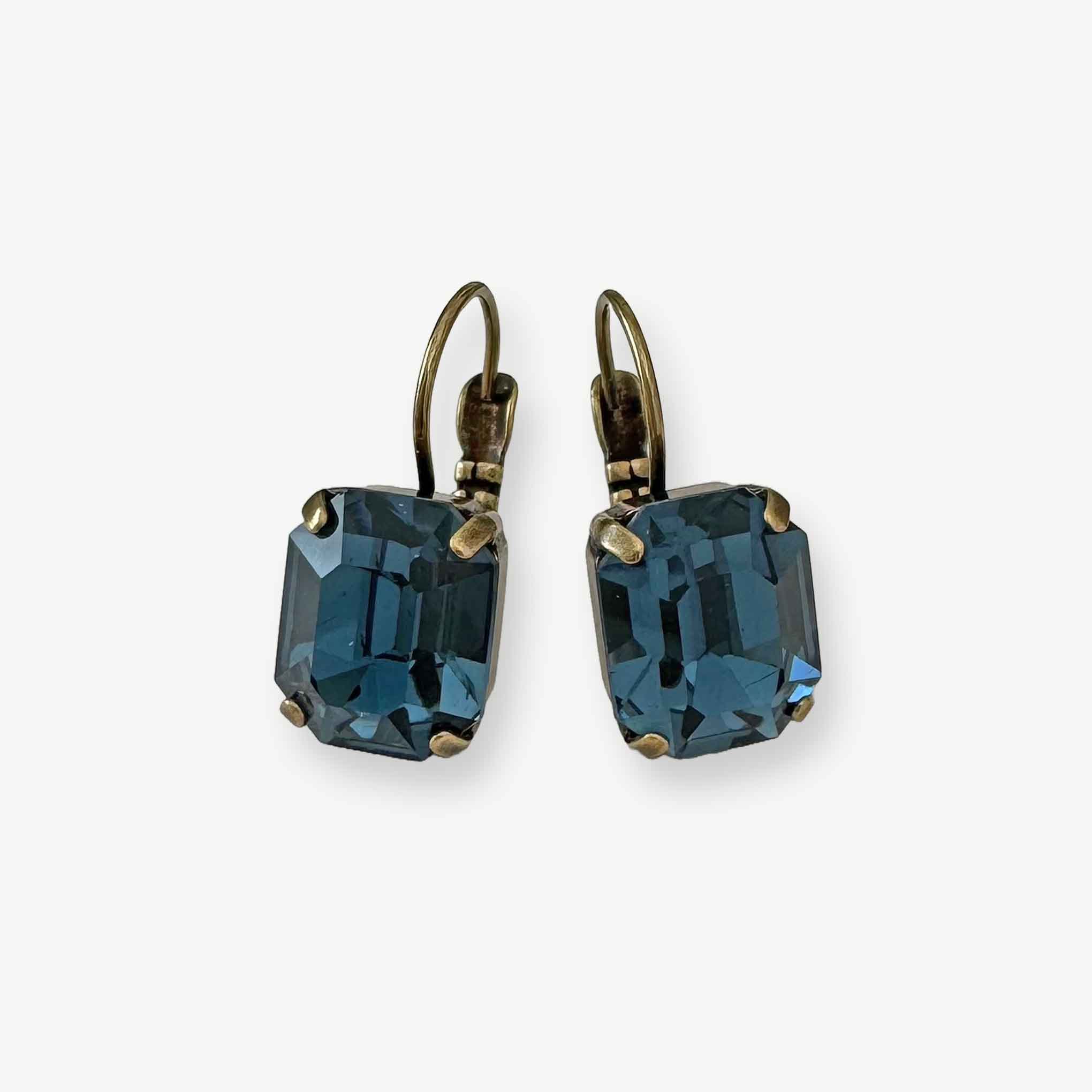 Emerald-cut blue crystal earrings shown in antique brass.