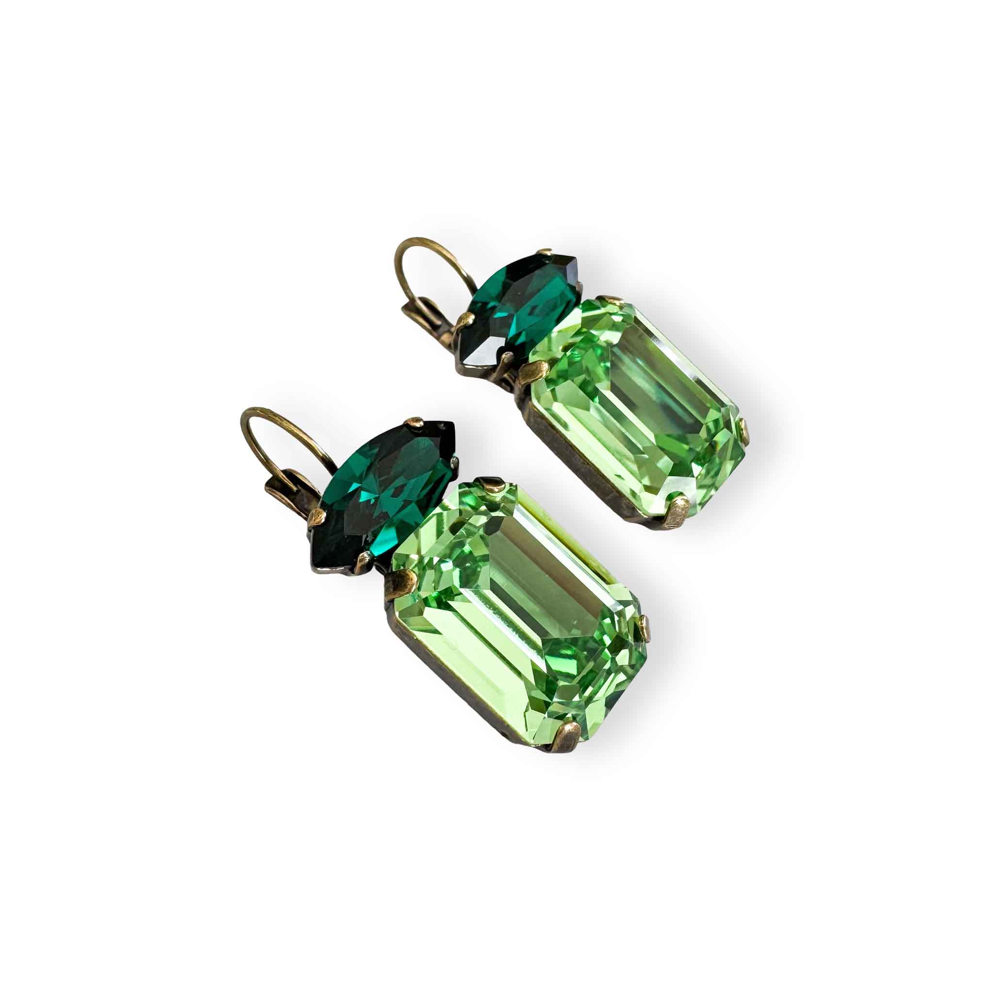 Side view of dark and light green crystal drop earrings with emerald and marquise cut crystals shown in antique brass.