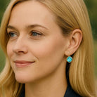 Young woman wearing aquamarine colored earrings by Petite Margaux.
