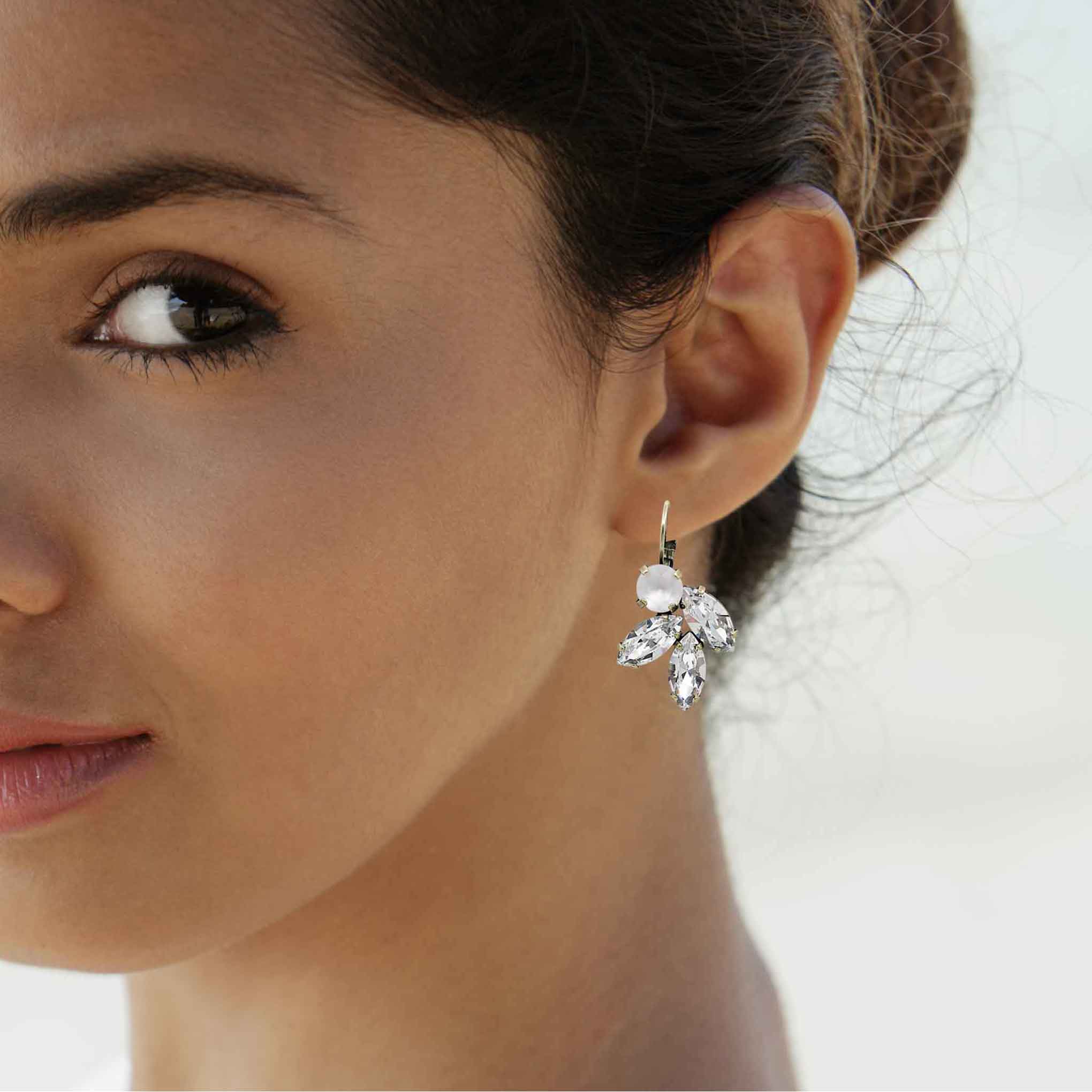 Woman wearing clear crystal rhinestone drop earrings.