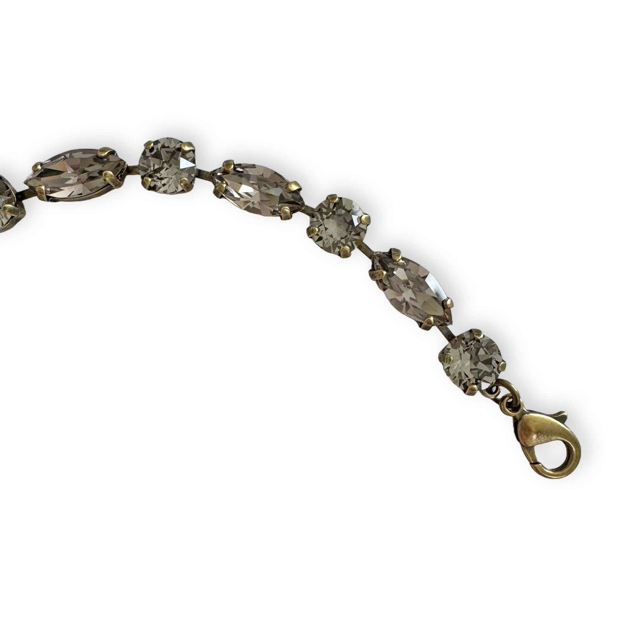 close up of antique brass version of warm gray crystal bracelet.