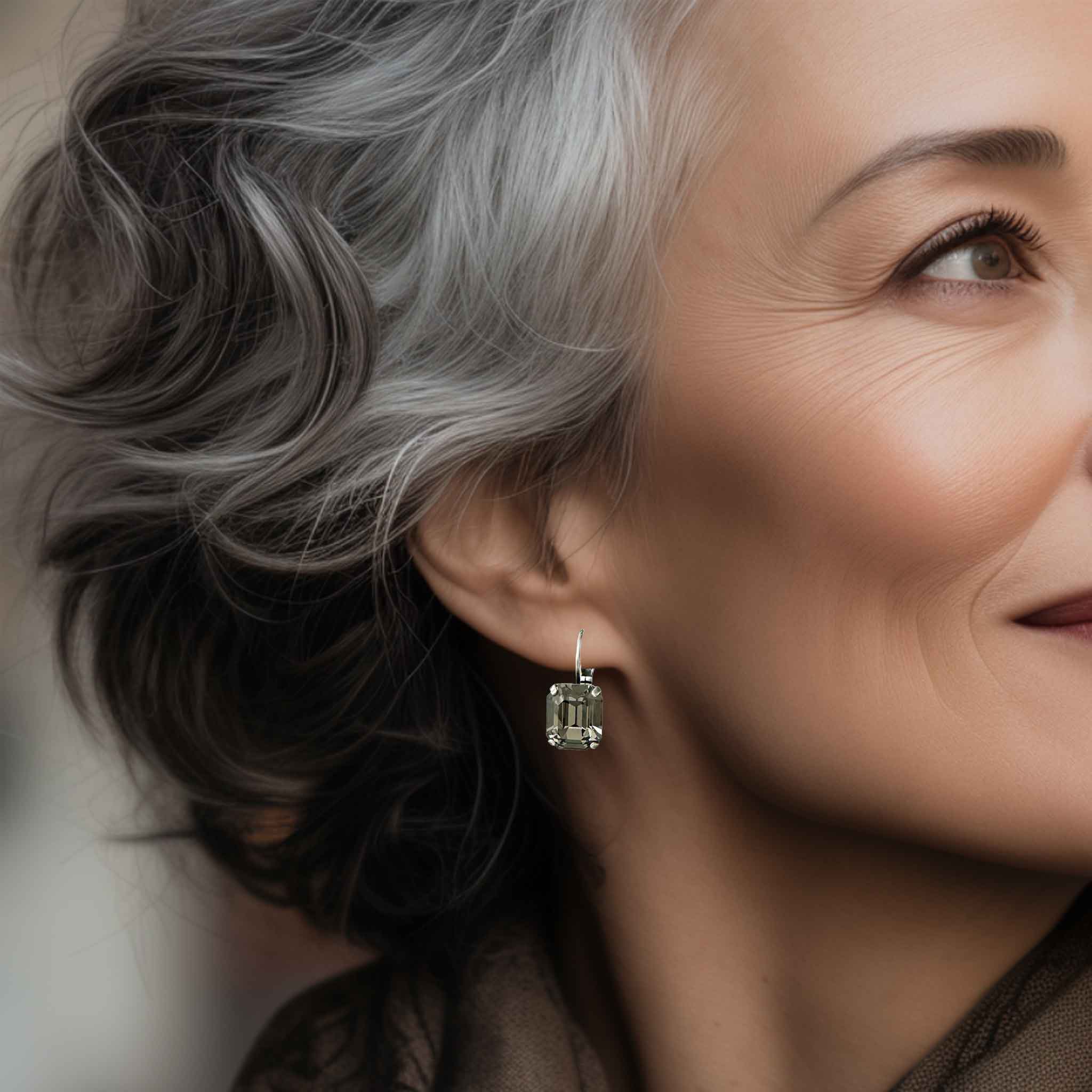 Mature woman wearing simple, yet stunning black stone drop style earrings.