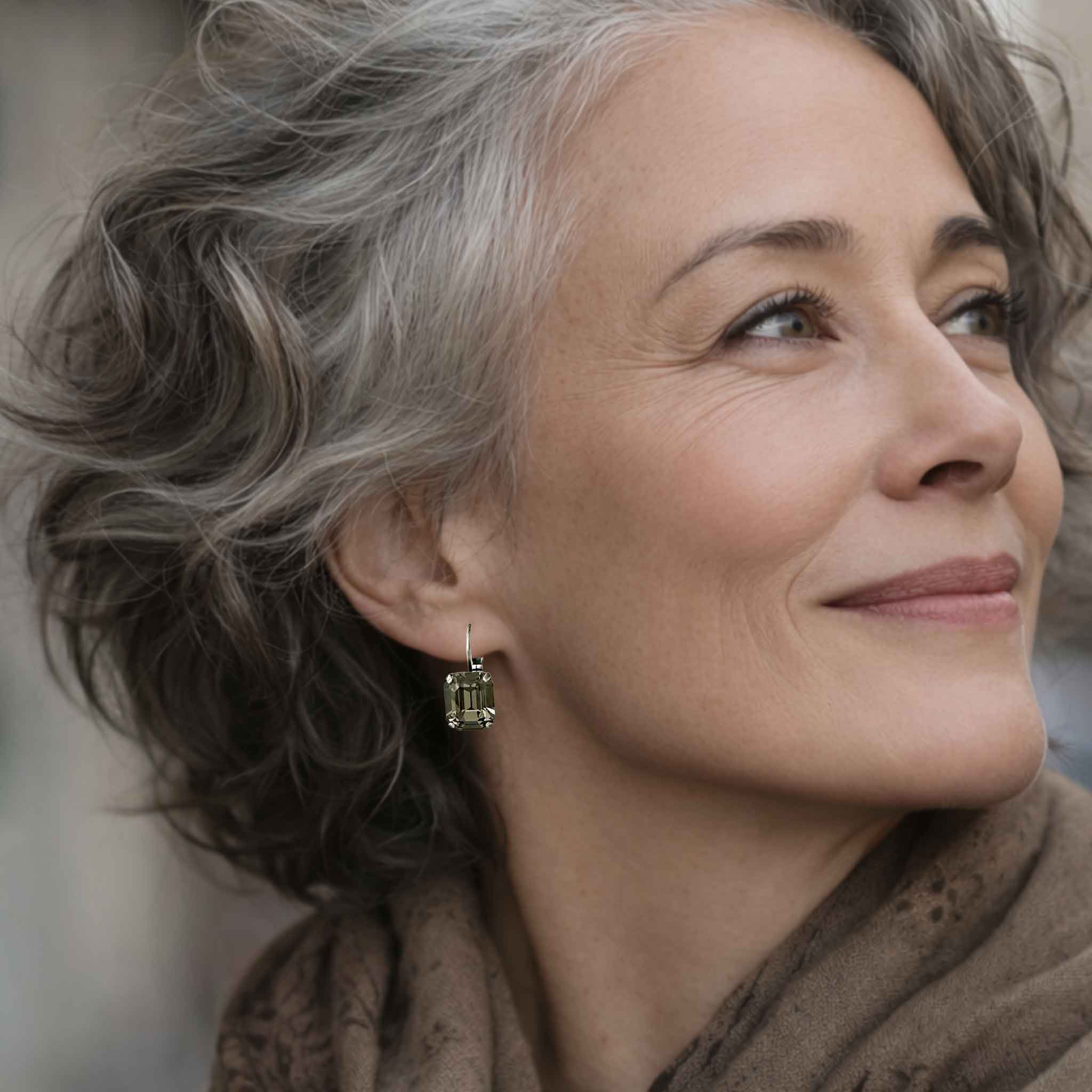 Mature woman wearing simple, yet stunning black stone drop style earrings.