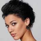 Black woman wearing onyx black rhinestone earrings shown in gold.