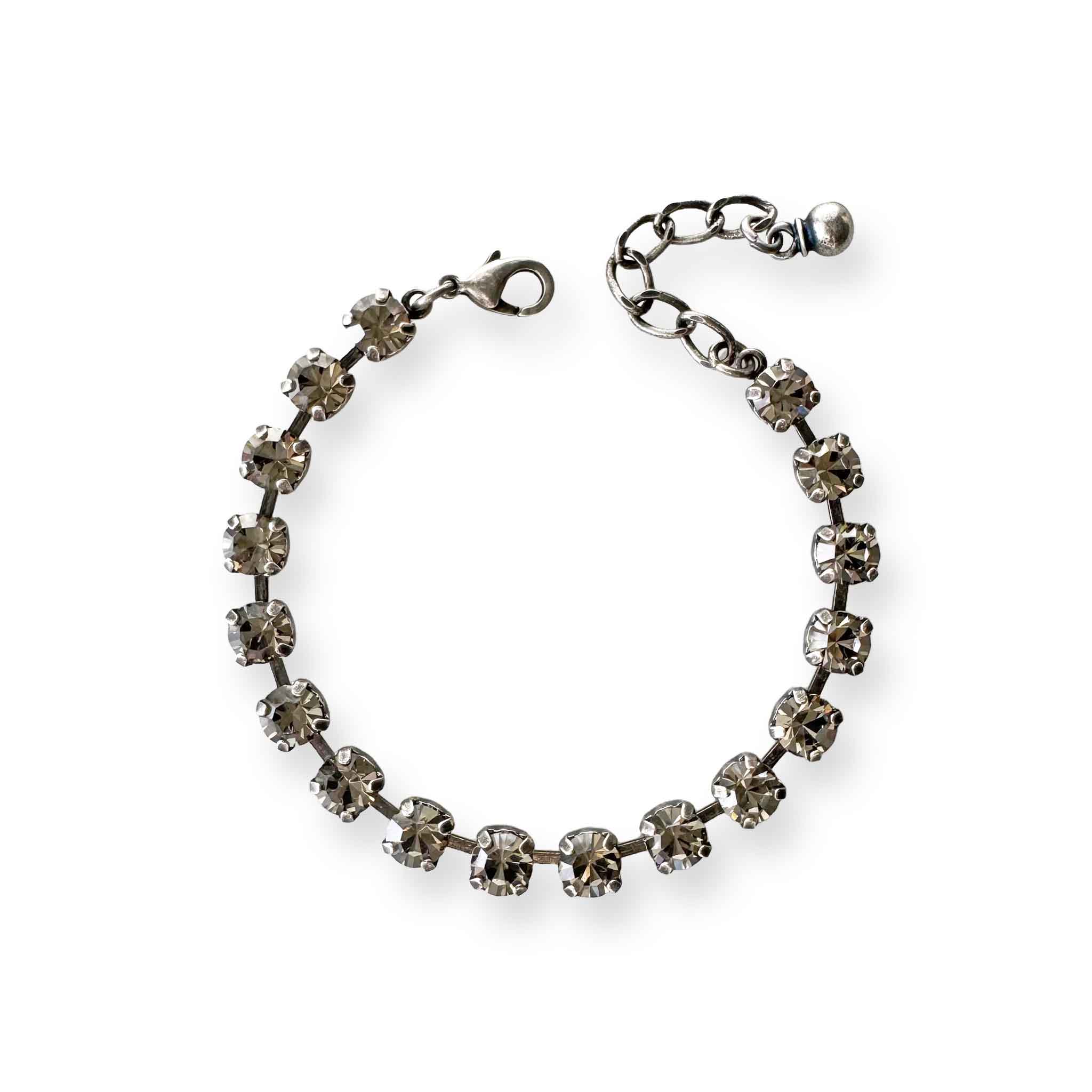 Crystal tennis bracelet of black diamond crystals shown in antique silver.