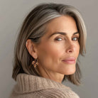 Attractive boomer woman wearing brown crystal earrings by Petite Margaux.