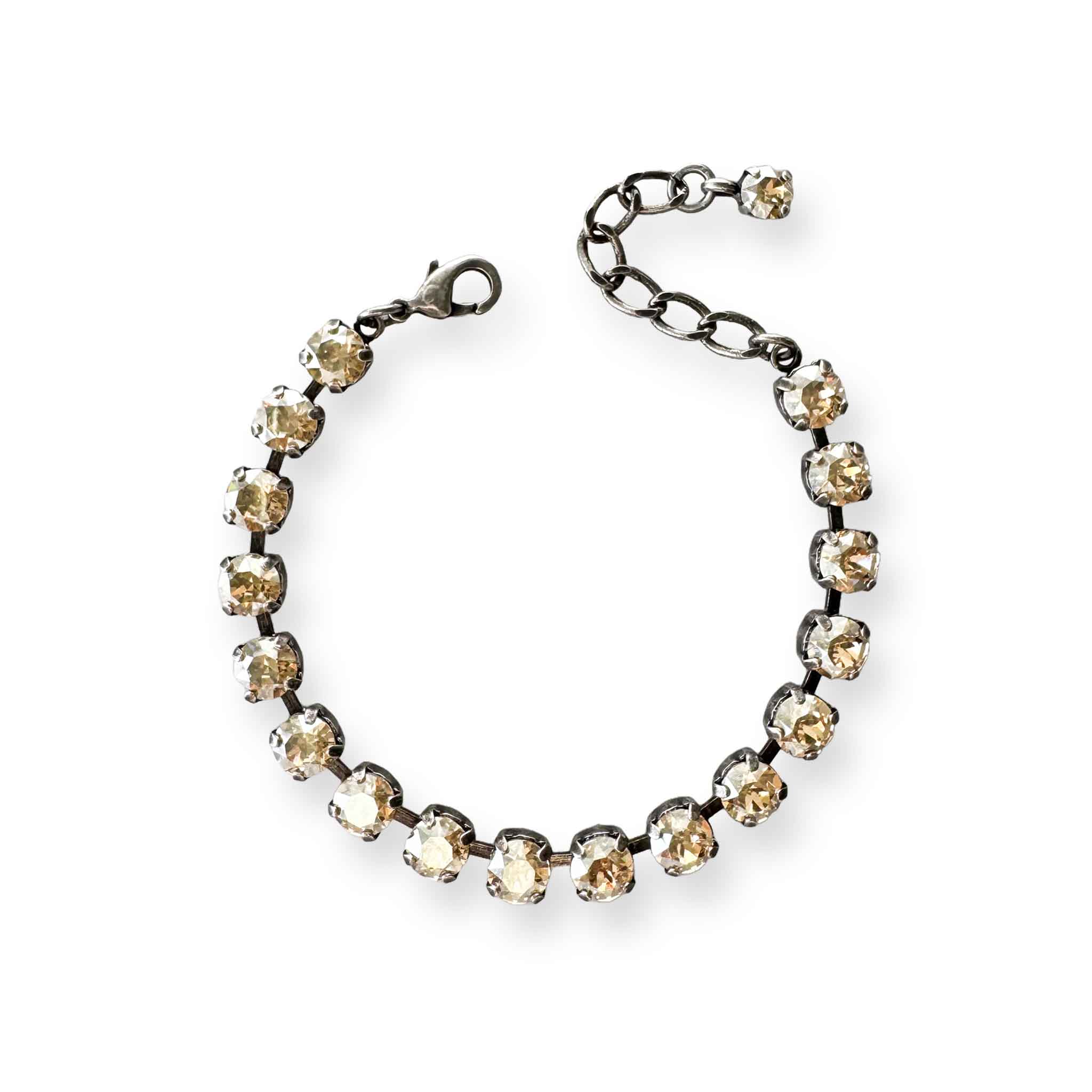 Crystal tennis bracelet of honey-colored champagne crystals shown in antique silver.