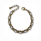 Clear crystal and antique brass link bracelet on white background.