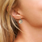 Close up of yellow rhinestone drop earring on a woman. Shown in silver.