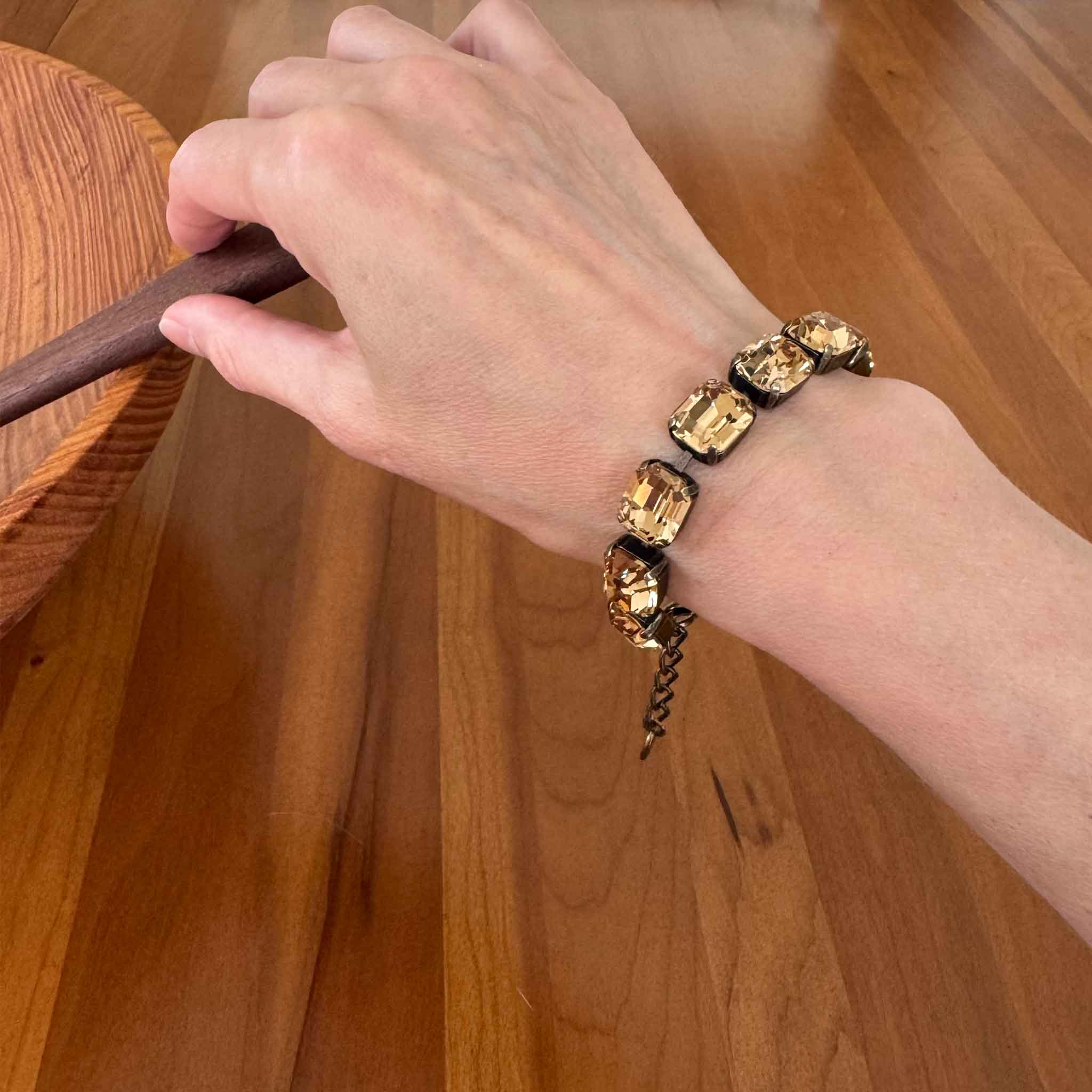 Light Colorado topaz crystal bracelet by Petite Margaux shown on a wrist. Emerald cut in antique brass setting.