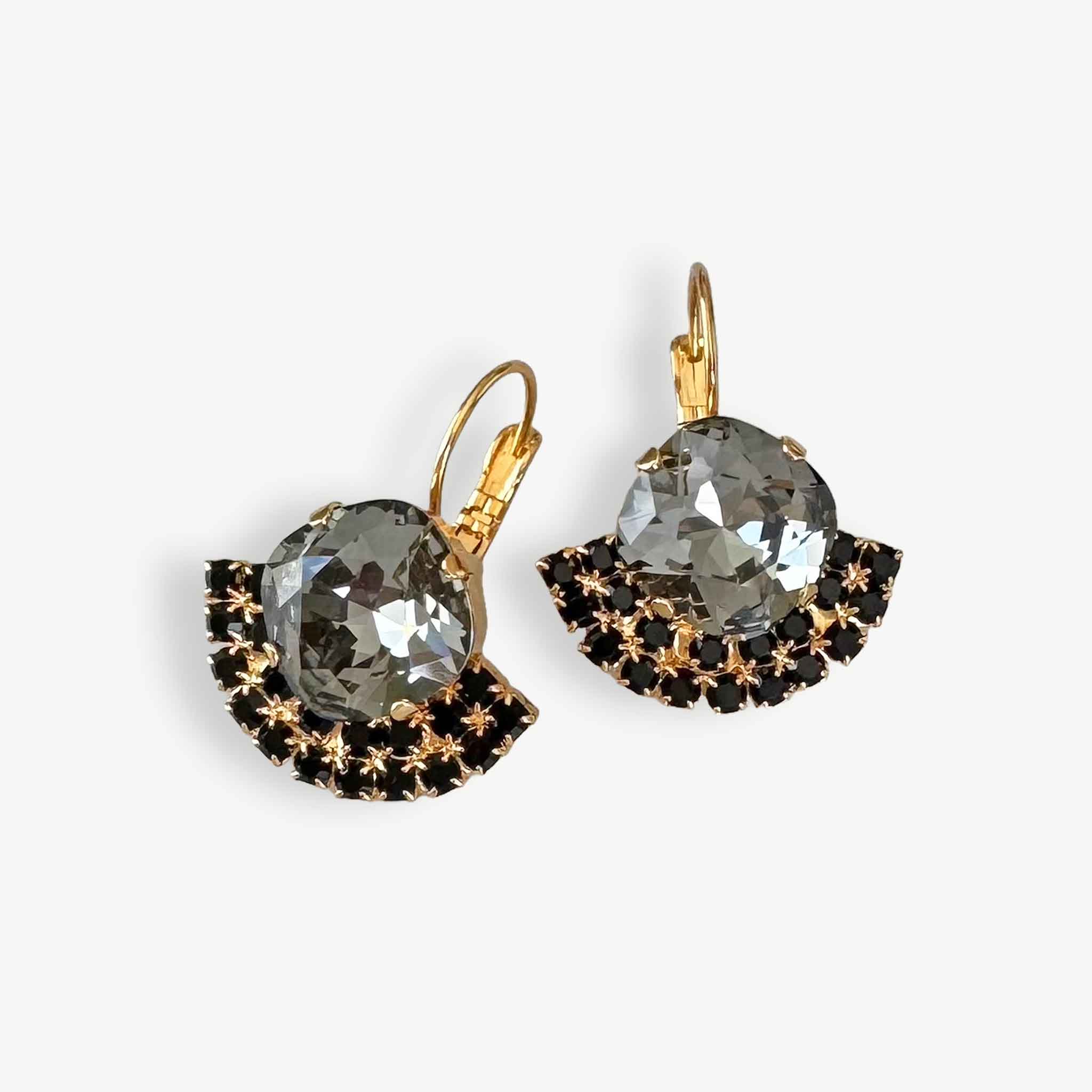 Pair of crystal earrings with gold and black fan-shaped designs on a white background