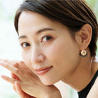 Model wearing black and gold crystal rhinestone earrings. Classic, fan-shape.