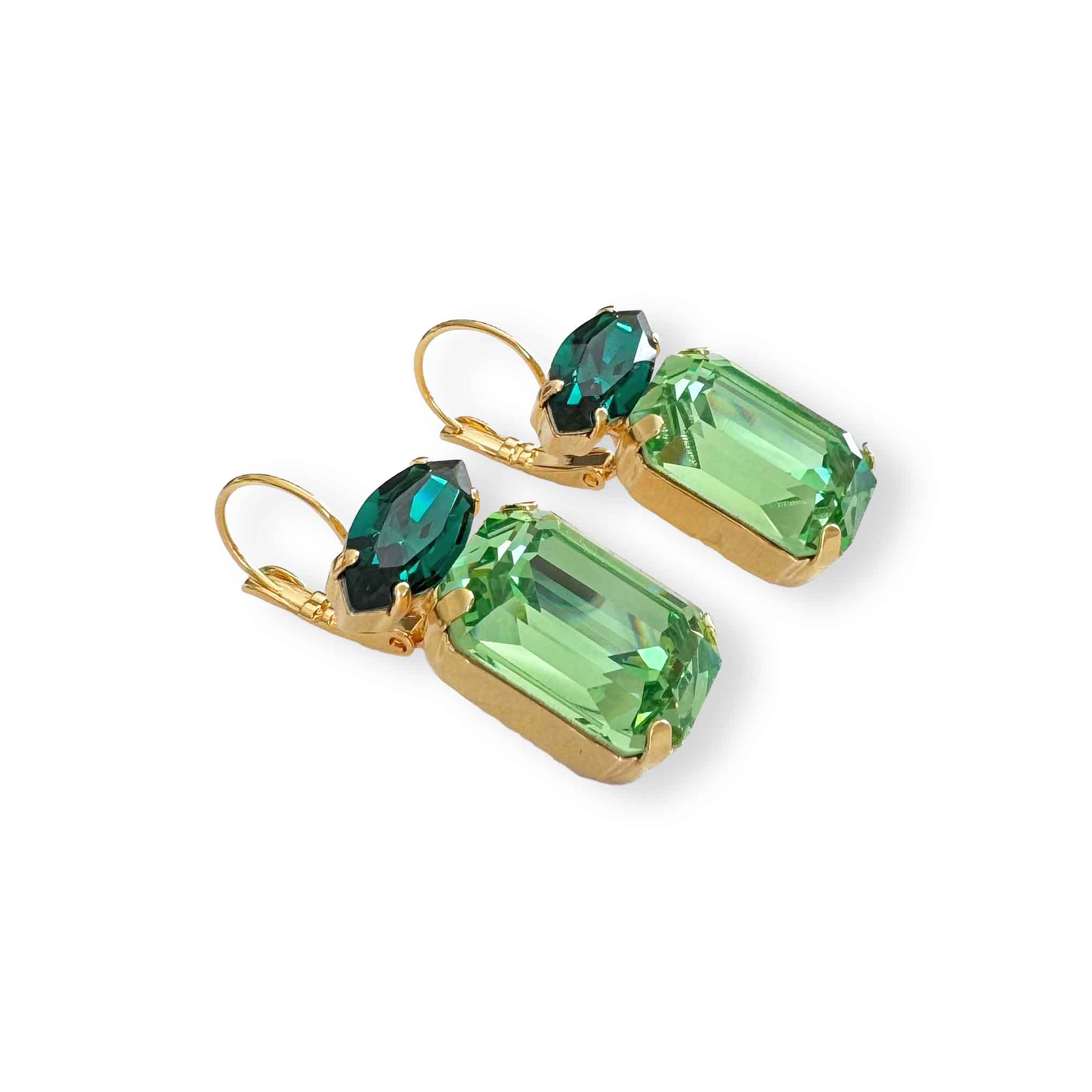 Side view of dark and light green crystal drop earrings with emerald and marquise cut crystals shown in yellow gold plate.