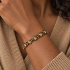 Light topaz crystal bracelet in antique brass worn on a darker-skinned woman with a camel sweater.