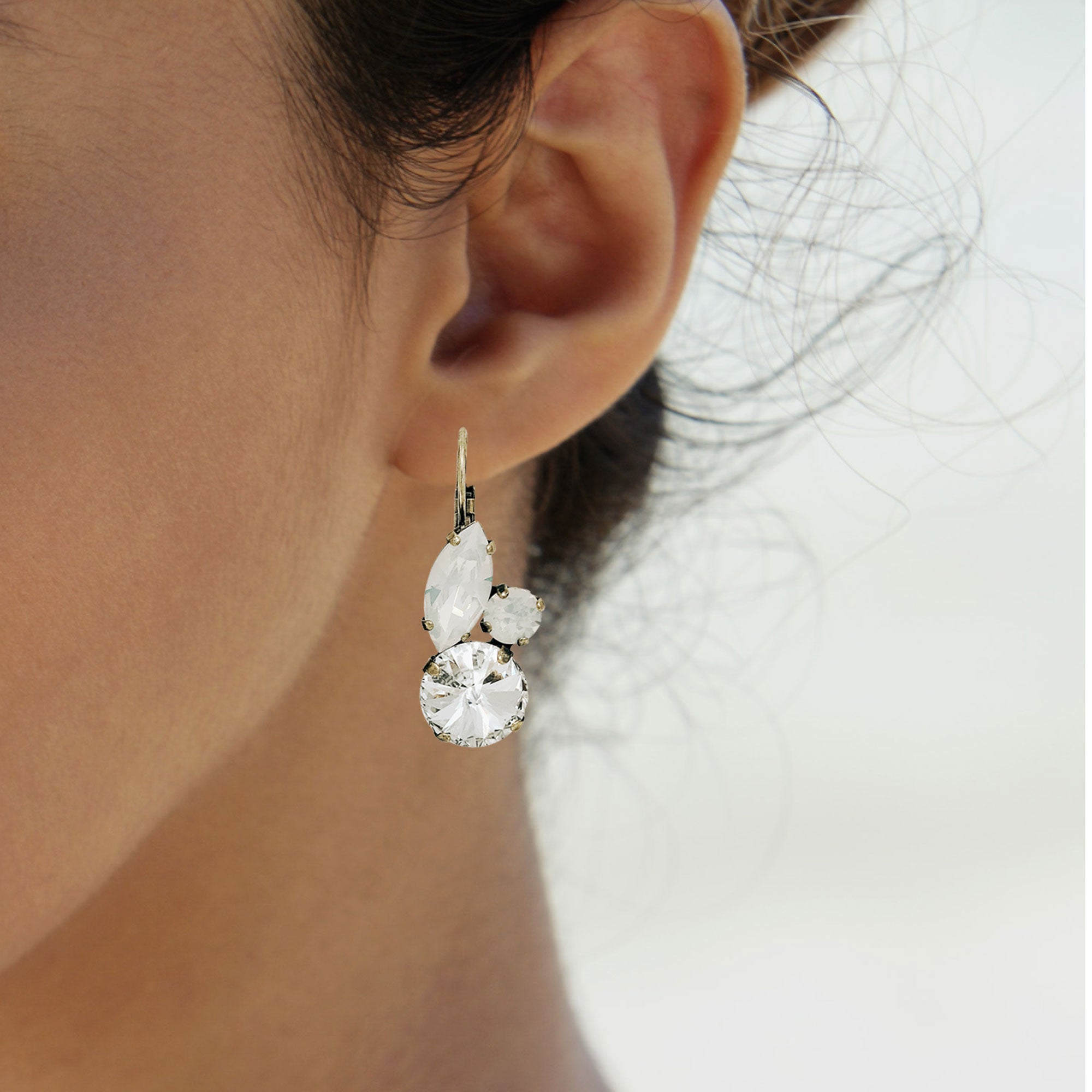 Woman wearing white opal crystal drop earrings with Swarovski crystals.