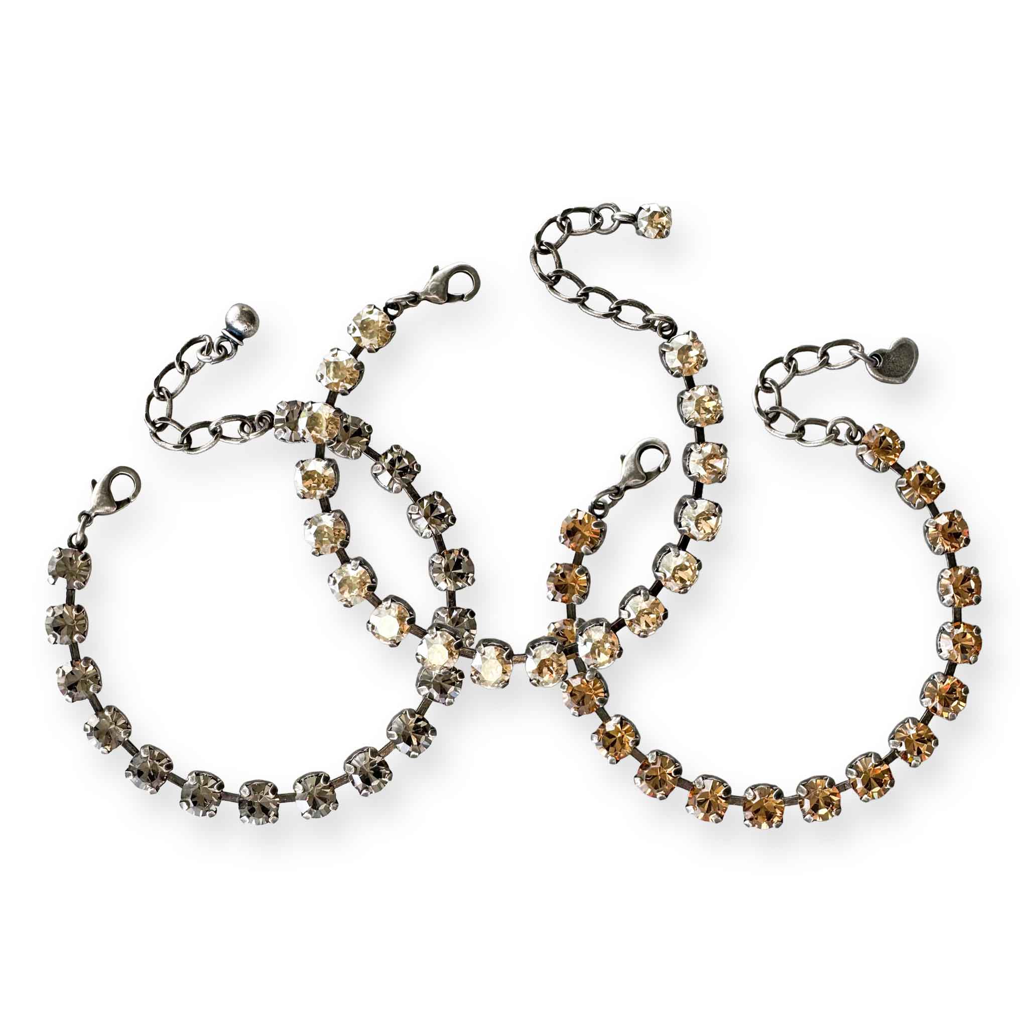 Set of three crystal tennis bracelets in a mix of warm neutral shades - black diamond, champagne and light smoked topaz.  Shown in antique silver.