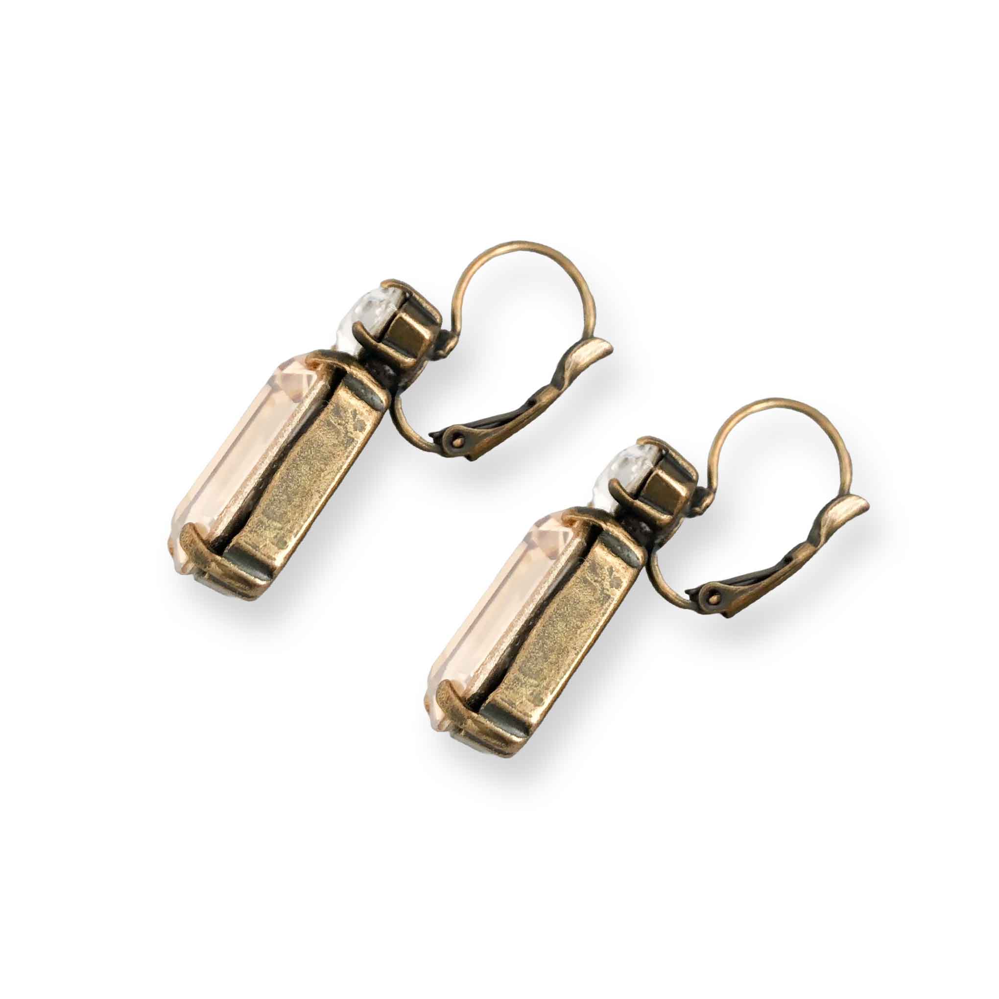 Side view of emerald cut champagne crystal statement earrings shown on white background.