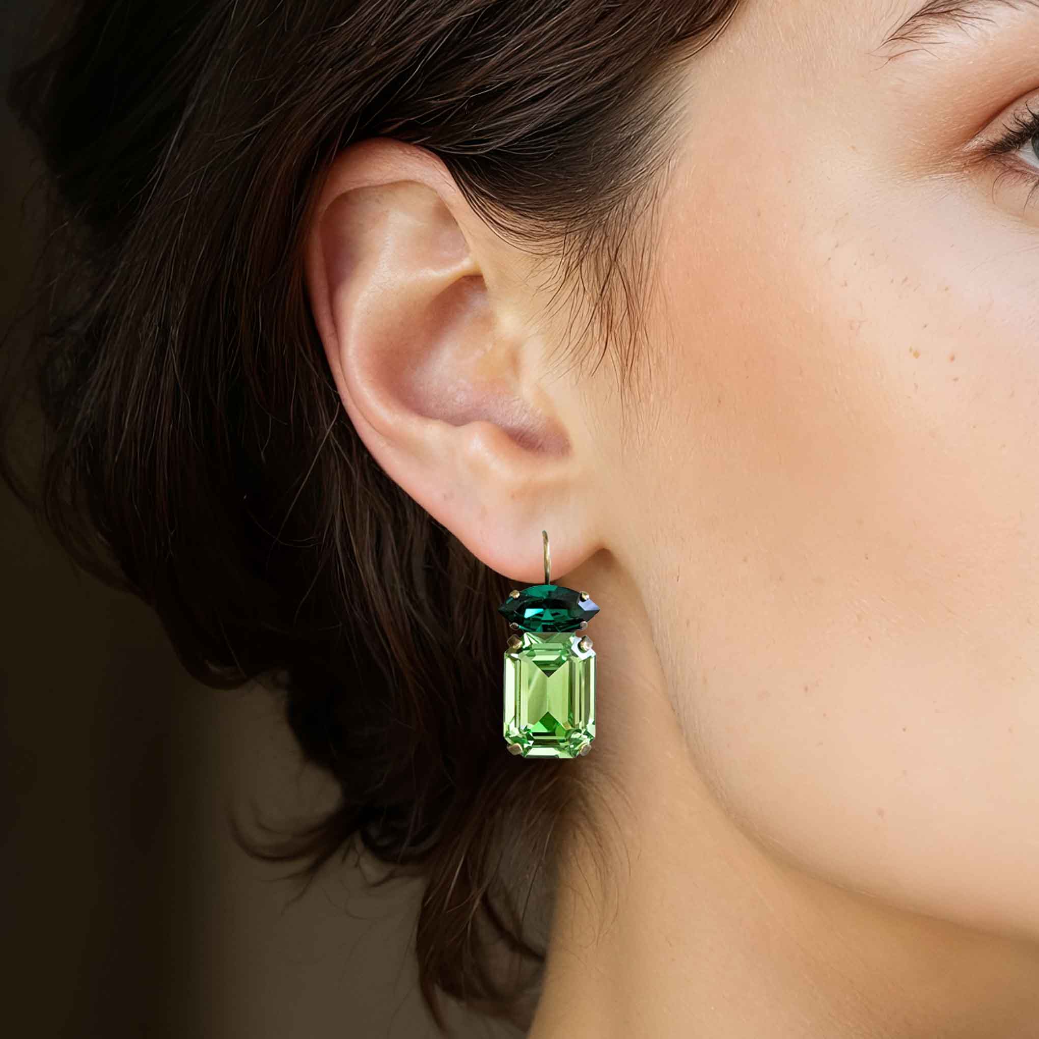 Woman wearing green crystal drop statement earrings by Petite Margaux.