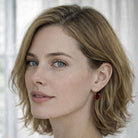 Close-up of a woman with light brown hair and freckles, wearing a red crystal earring.