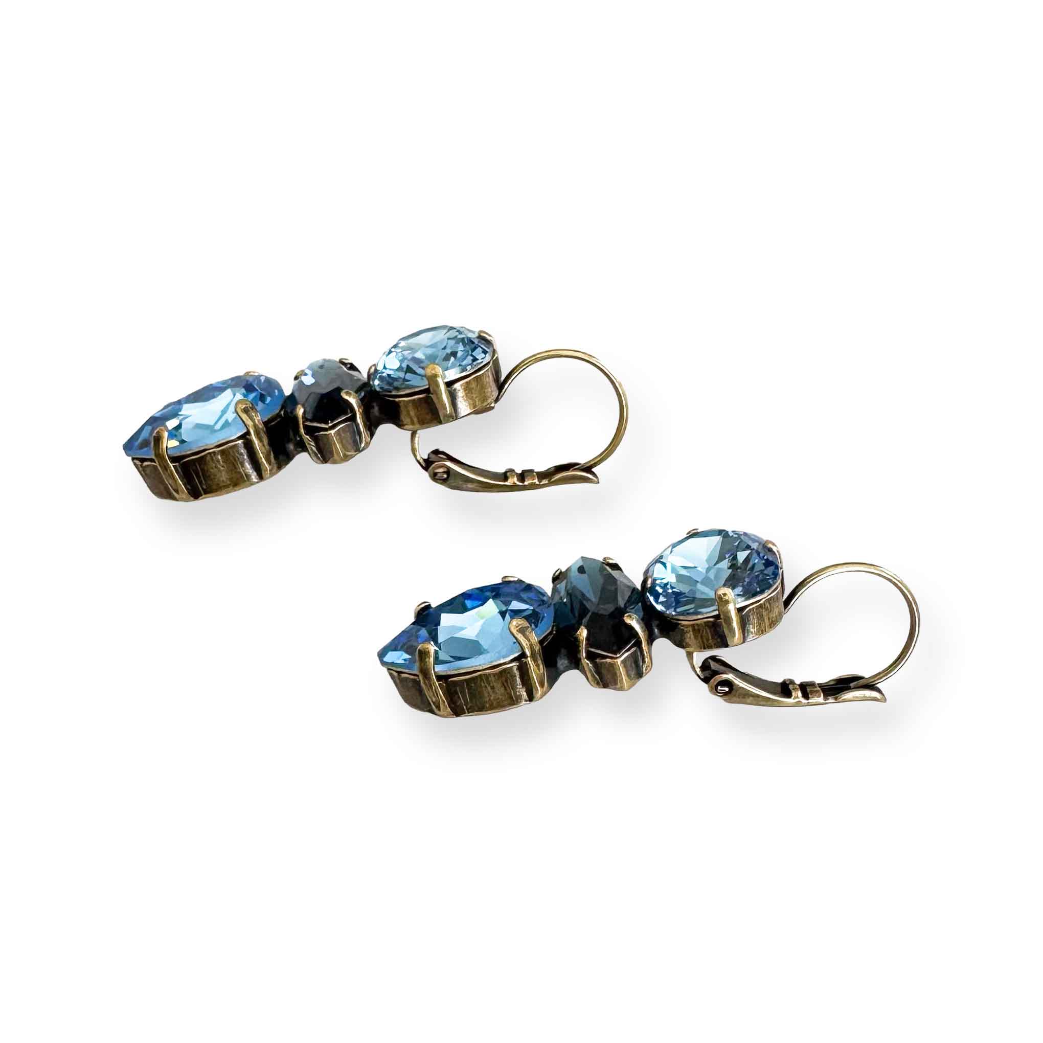 Side view of antique brass crystal blue statement earrings.