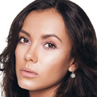 Small white opal halo crystal drop earrings on brunette bride.