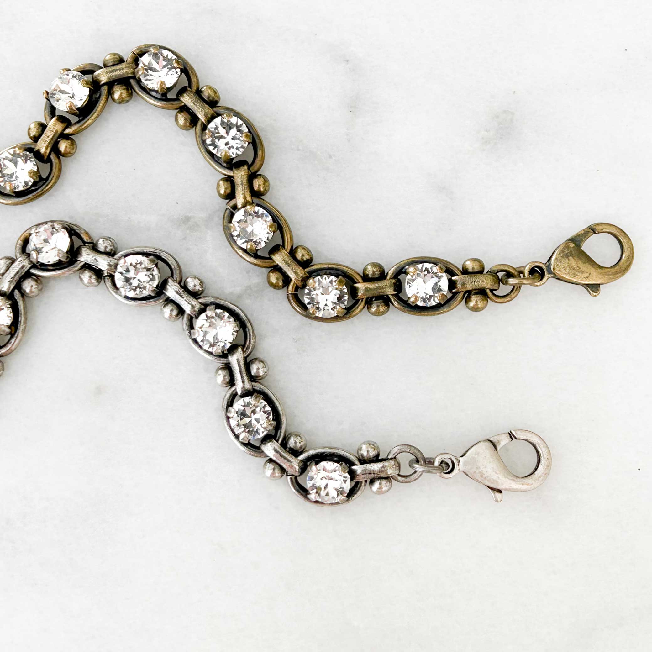 Link style bracelet with clear crystals set into the links. Shown in antique brass and antique silver.