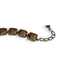 Close up of brown bracelet by Petite Margaux. Fine emerald cut European crystals set in warm antiqued brass with an adjustable extender.