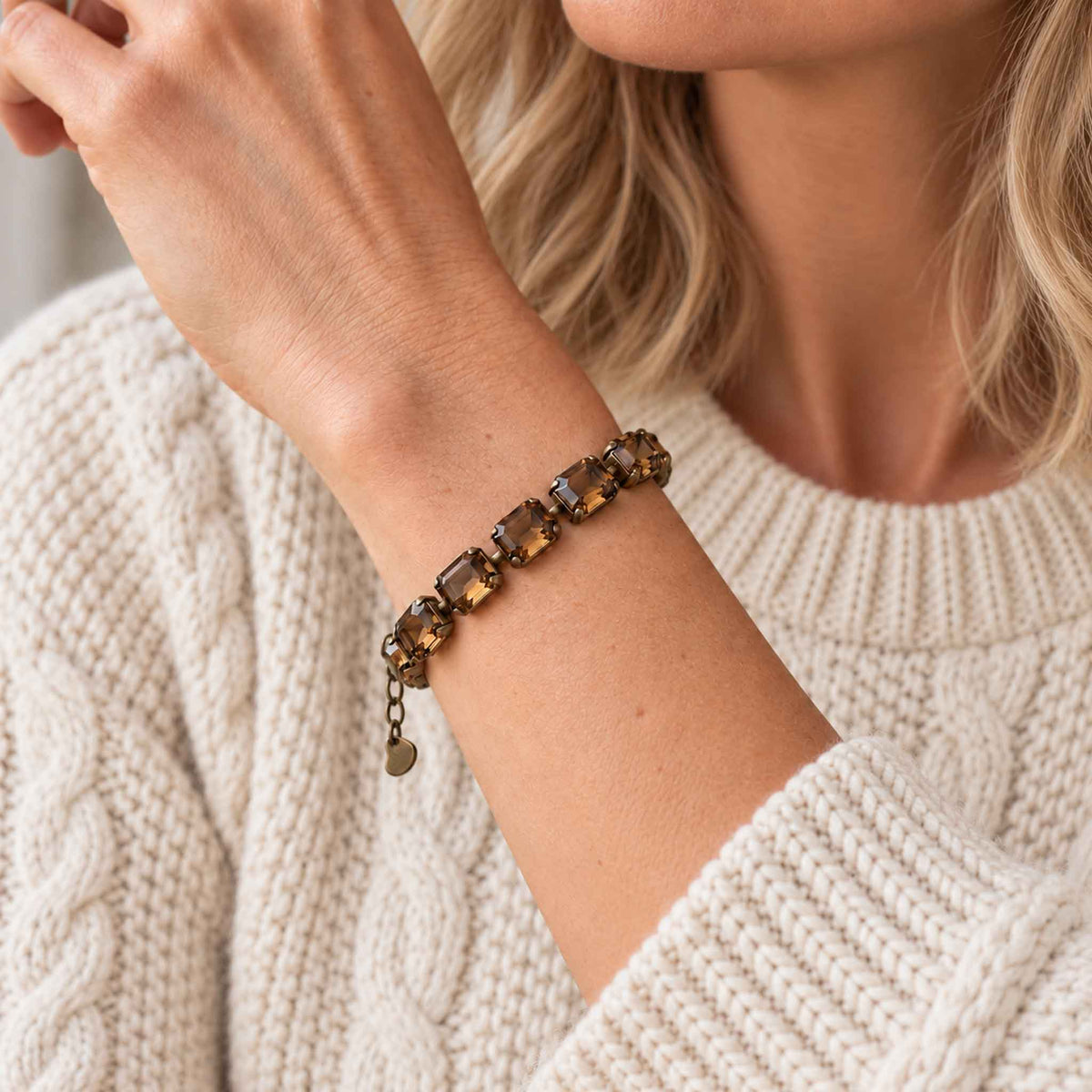woman wearing brown topaz crystal bracelet in antique bronze with a natural colored fisherman sweater.