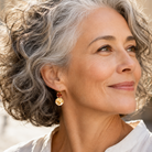 Close-up of brown and gold crystal earrings on a stylish mature woman.